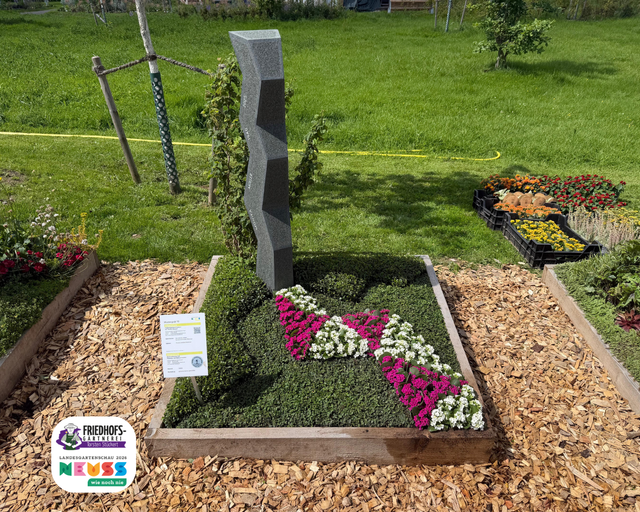 Pflegevoll gestaltetes Grab mit Blumenbeet, Stein und Namensschild auf Friedhof.